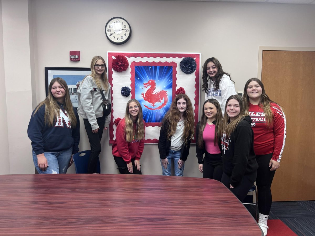 The journalism girls showing off the new and improved bulletin board in the conference room.